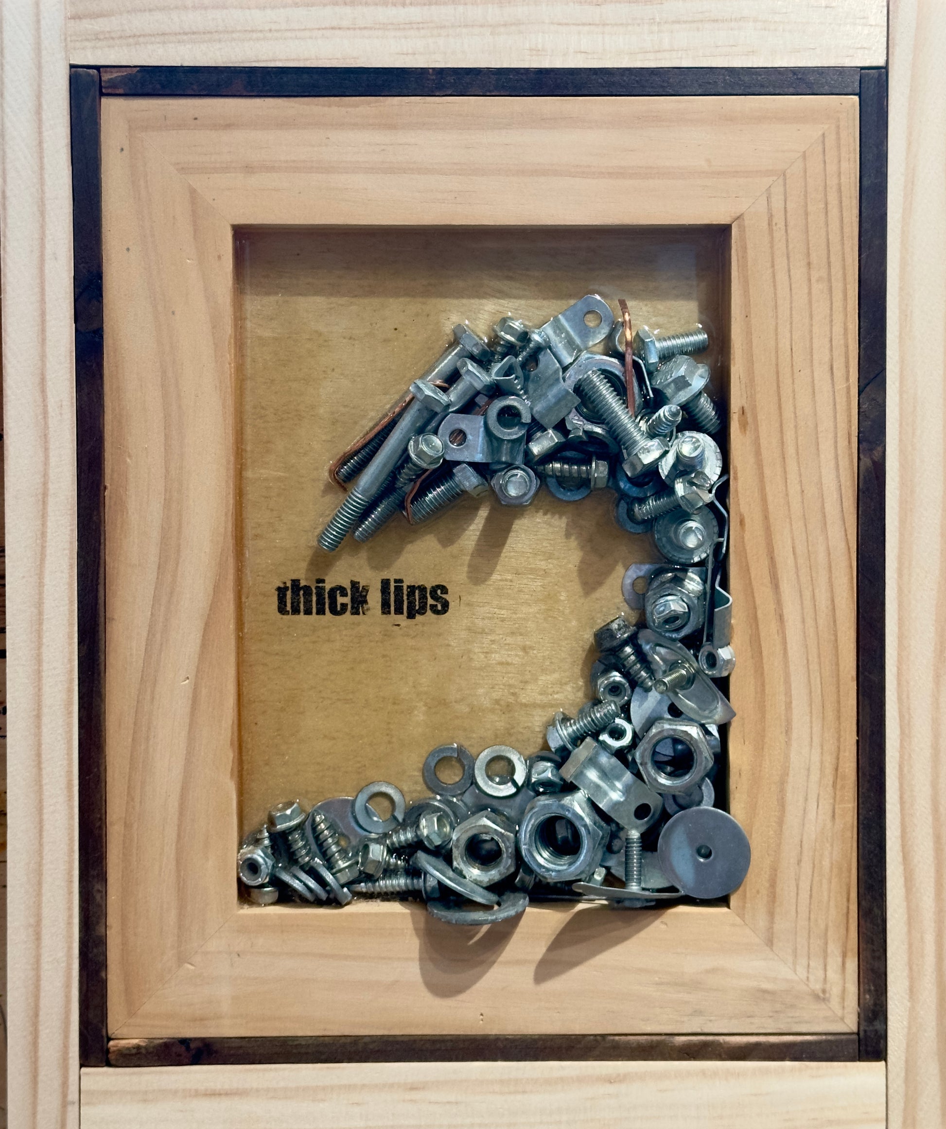 Wave made of nuts and bolts on wood panel toner